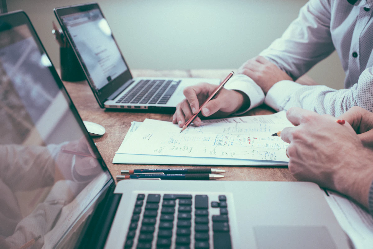 Profissionais analisando documentos e gráficos em uma mesa