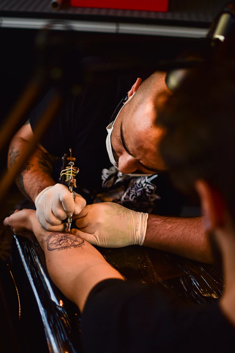 Artista trabalhando em uma tatuagem dentro de um estúdio